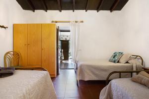 a room with two beds and a wooden cabinet at Casa la solapa in Pájara
