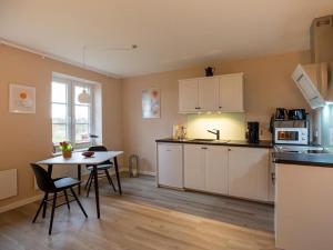 a kitchen with a table and chairs in a room at Fewo Op de Warft in Pellworm