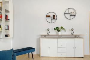 a living room with a white cabinet and two mirrors at Ferienwohnung Spree - Oase in Spremberg