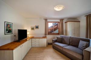 a living room with a couch and a flat screen tv at Oberhölzlhof in Valdaora di Sopra