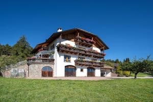 a large building with flowers on the balcony at Stücklhof Wohnung Edelweiss in San Genesio Atesino +23 photos