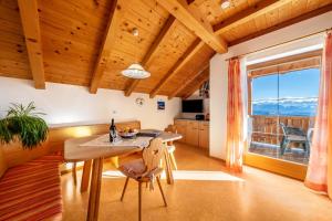 a kitchen with a table and a large window at Stücklhof Wohnung Edelweiss in San Genesio Atesino
