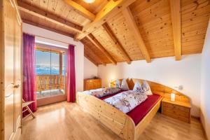 a bedroom with a bed and a large window at Stücklhof Wohnung Edelweiss in San Genesio Atesino