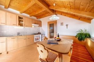 a kitchen with a wooden table and a cross on the wall at Stücklhof Wohnung Edelweiss in San Genesio Atesino