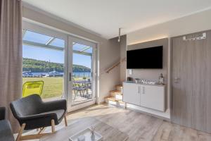 a living room with a tv and a large window at Ferienanlage am Seerand in Joachimsthal