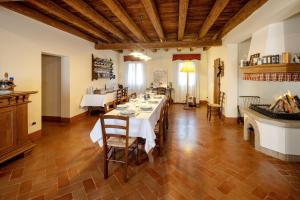a dining room with a long table and a fireplace at Agriturismo Marzanino in Torre di Mosto