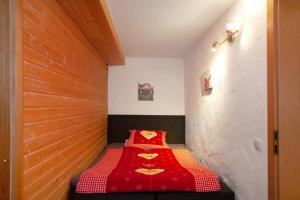 ein Bett in einem Zimmer mit einer roten Decke in der Unterkunft Obermaiselstein in Obermaiselstein