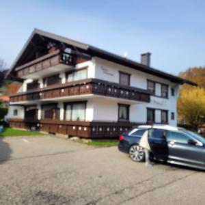Ein schwarzes Auto parkte vor einem Haus in der Unterkunft Obermaiselstein in Obermaiselstein
