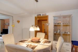 ein Esszimmer mit einem Tisch und weißen Stühlen in der Unterkunft Obermaiselstein in Obermaiselstein