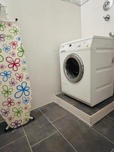 a washing machine in a bathroom with a shower curtain at Minas Ferienwohnung in Dormagen