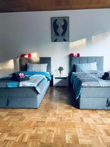 two beds in a room with wooden floors at Minas Ferienwohnung in Dormagen