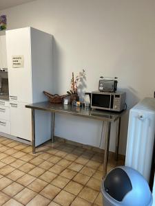 a kitchen with a table with a microwave and a refrigerator at Minas Ferienwohnung in Dormagen