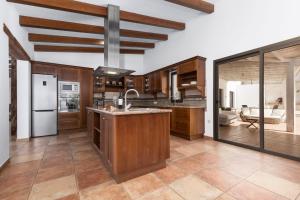 a kitchen with wooden cabinets and a large island at Villa Selena in Pájara +6 photos