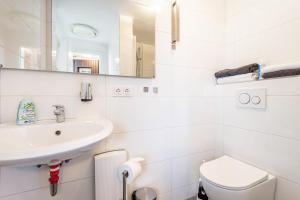 a white bathroom with a sink and a toilet at Ferien- Monteurwohnung in Nürnberg in Nuremberg +17 photos
