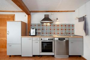 a kitchen with a stove and a refrigerator at Alpenchalet Pfronten in Pfronten