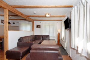a living room with a couch and a tv at Alpenchalet Pfronten in Pfronten