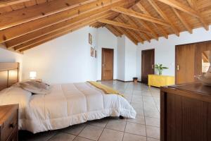 a bedroom with a large bed and wooden ceilings at Vista da Baía - Casa do Aniceto in Almas