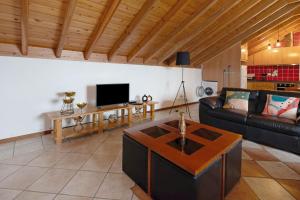 a living room with a couch and a tv at Vista da Baía - Casa do Aniceto in Almas