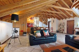 a living room with a leather couch and a kitchen at Vista da Baía - Casa do Aniceto in Almas
