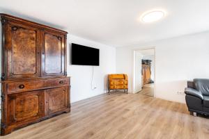 a living room with a large wooden cabinet and a couch at Ferien- Monteurwohnung in Nürnberg in Nuremberg