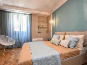 a bedroom with a bed and a chair and a window at Modern Central Apartment in Salò