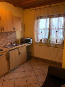 a kitchen with a sink and a window with curtains at Ferienwohnung Stark in Scheßlitz