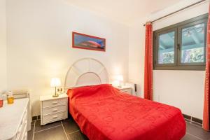 a bedroom with a red bed and a window at Maison avec piscine en Catalogne in Aramunt +17 photos