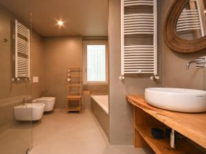 a bathroom with a sink and a tub and a toilet at Modern Central Apartment in Salò