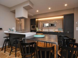 a kitchen with a table and some black chairs at Modern Central Apartment in Salò +27 photos