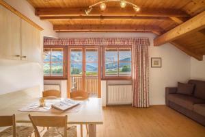a living room with a table and a large window at Oberhölzlhof in Valdaora di Sopra