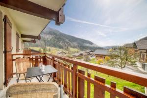 a balcony with a table and chairs and a view at Studio cabine Le Charvet in Le Grand-Bornand +13 photos