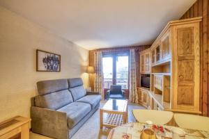 a living room with a couch and a table at Studio cabine Le Charvet in Le Grand-Bornand