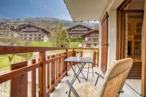 a patio with a table and chairs on a balcony at Studio cabine Le Charvet in Le Grand-Bornand