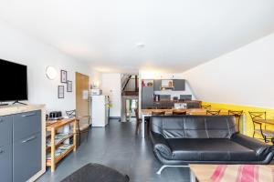 a living room with a leather couch and a kitchen at Bacchus Holiday Homes in Bacharach