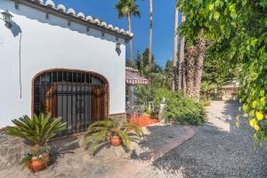 a white house with a gate and palm trees at El Amanecer in Motril