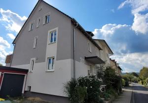 a gray building with a garage on a street at Apartement Hangarstein in Kassel