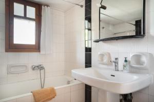 a white bathroom with a sink and a bath tub at Villa Sugar Town in Zacharo +30 photos