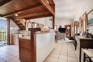 an open kitchen with wooden ceilings and a dining room at Villa Sugar Town in Zacharo