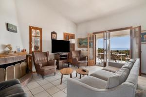 a living room with a couch and chairs and a television at Villa Sugar Town in Zacharo