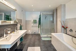 a bathroom with two sinks and a shower at Apartement Hangarstein in Kassel +15 photos