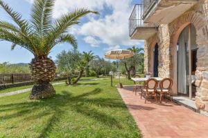 a patio with a palm tree and a table and chairs at Appartamenti Castle in Campo nell'Elba