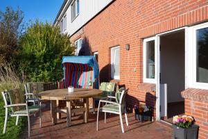 a wooden table and chairs on a patio at Ferienhof Dethlefsen in Pellworm