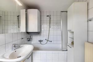 a white bathroom with a sink and a shower at Ferienwohnung Zu Hause auf Zeit in Balingen +11 photos