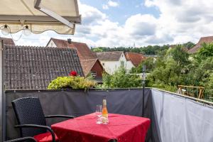 a red table with a bottle of wine on a balcony at Ferienwohnung Zu Hause auf Zeit in Balingen