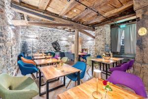 a restaurant with wooden tables and colorful chairs at Gästehaus Siebter Himmel in Burkheim