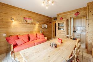 a living room with a couch and a table at Le Col Panoramic in La Toussuire