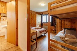 a bedroom with two bunk beds and a bathroom at Le Col Panoramic in La Toussuire