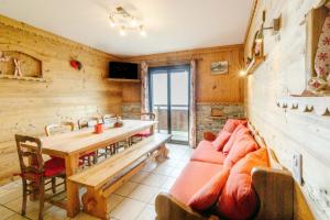 a living room with a couch and a table at Le Col Panoramic in La Toussuire