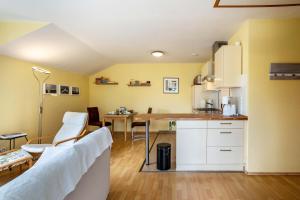 a kitchen with white cabinets and a table in a room at Ferienwohnung 'Sonneck' in Eckernförde