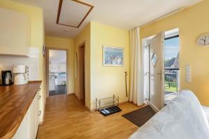 a kitchen and living room with yellow walls and wooden floors at Ferienwohnung 'Sonneck' in Eckernförde